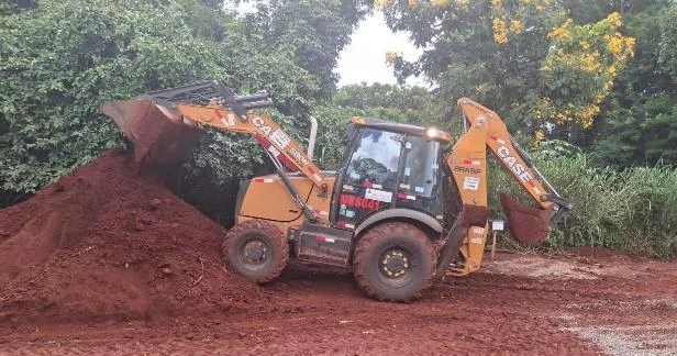 Retroescavadeira com operador em movimentação de solo